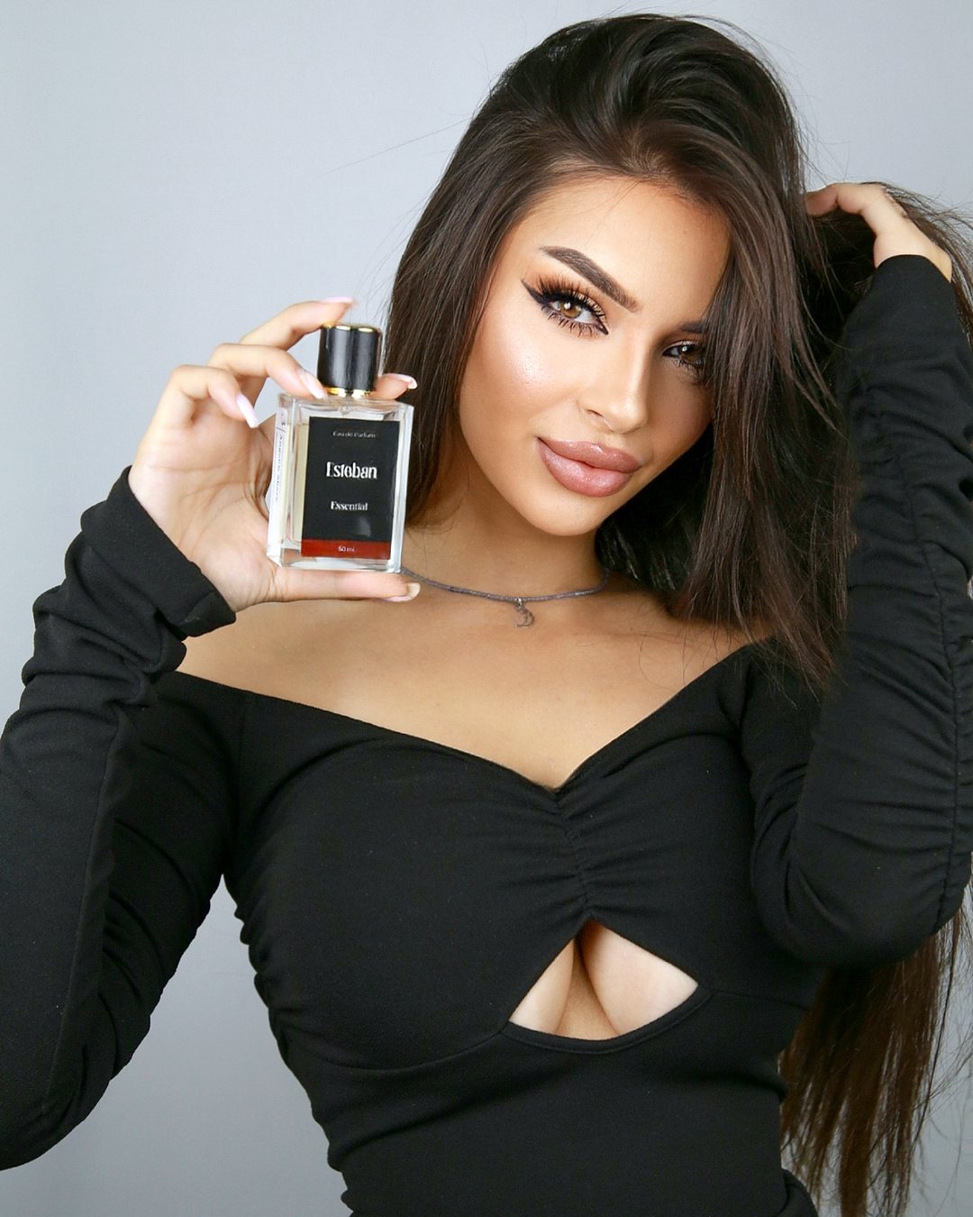 Clientă cu un parfum Maison d'Esteban ridicat lângă față