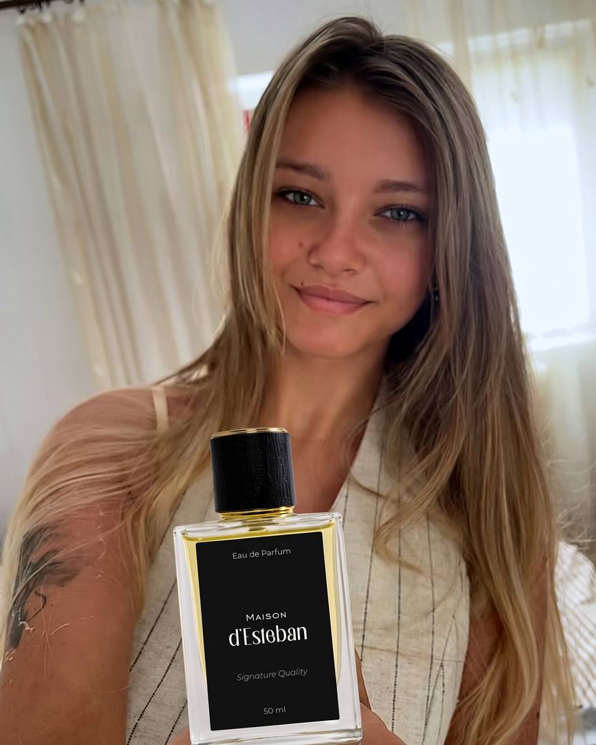 Clientă zâmbitoare cu o sticlă Maison d'Esteban Essential