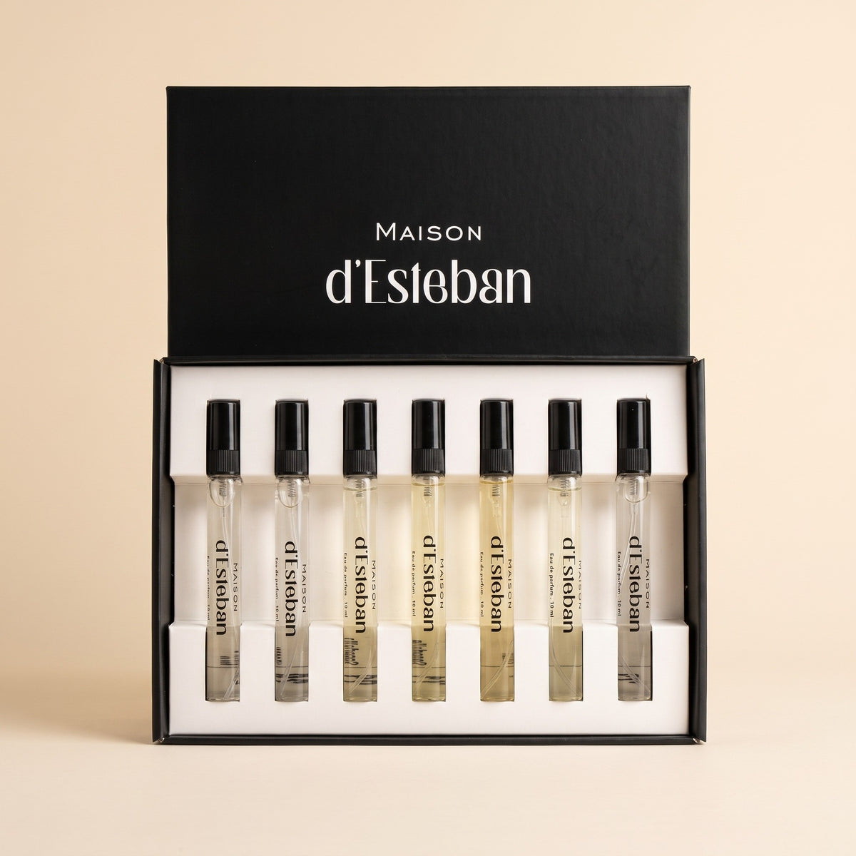 Set 7 parfumuri unisex Maison d'Esteban, cutia deschisă cu 7 fiole de 10 ml, pe fundal bej crem