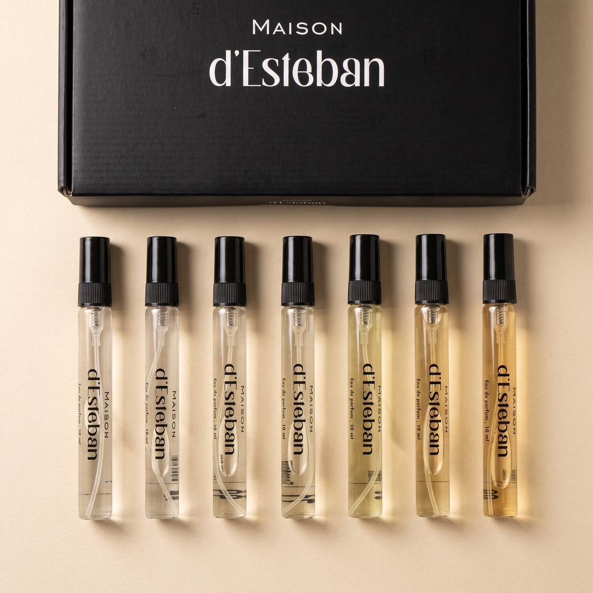 Cutia Maison d'Esteban și cele 7 fiole de 10 ml unisex așezate în rând, de la limpede la chihlimbar